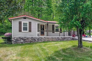 A single-story house with a red roof, a stone foundation, and a porch with a bench. - New-Sunfish Cottage - Walk to Hidden Harbor Marina (Smithville)