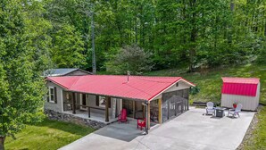 A two-story house with a red roof, a covered porch, and a small shed. - New-Sunfish Cottage - Walk to Hidden Harbor Marina (Smithville)