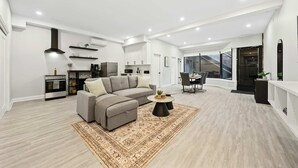 Ein modernes Wohnzimmer mit einem Ecksofa, einem Couchtisch und einem Essbereich mit Tisch und Stühlen.