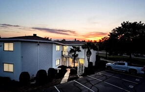 A two-story building with a garage, a driveway, and a parking lot. - 🌊Great Location | Walk to Beach | 2 Pools | Crystal Village II 26A⛱️ (Miramar Beach)