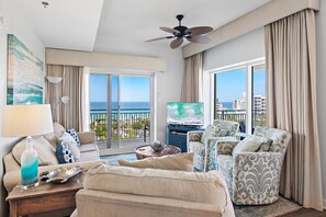 Ein Hotelzimmer mit Balkon, Deckenventilator, Fernseher und Meerblick.