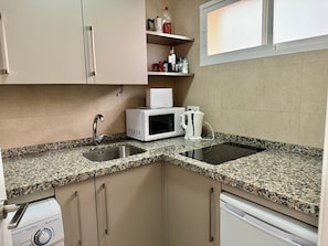 A kitchen with granite countertops, a microwave, a kettle, and a dishwasher. - 0. Diana 101 (Marbella)