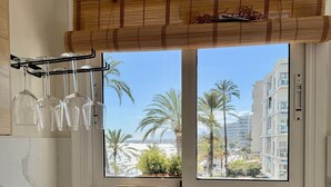 A kitchen with a window view, a wooden cutting board, a roll of paper towels, and a metal sink. - 0. Skol Marbella 111A (Marbella)