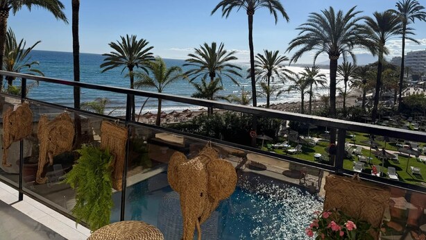 A pool area with a view of the ocean, palm trees, and a beach. - 0. Skol Marbella 111A (Marbella)