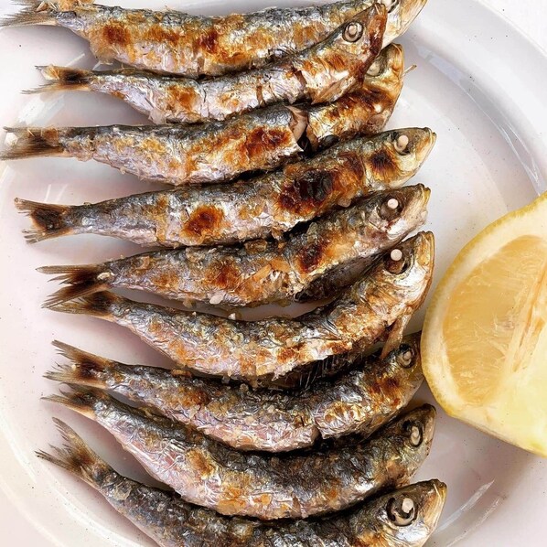 Un piatto di pesce alla griglia con spicchio di limone.