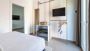Un dormitorio moderno con una cama, un televisor montado en la pared, un armario y una puerta corredera.