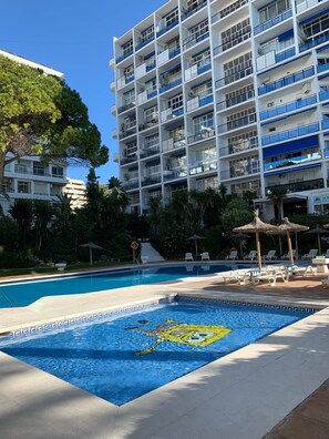 Ein Hotel mit Schwimmbad, Außenbereich und einem mehrstöckigen Gebäude mit Balkonen.
