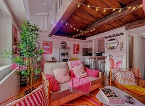 A cozy living room with a sofa, chairs, a plant, and a dining table. - Blush Heaven - Private apartment with POP ambience! With free fiber and Netflix! (Nancy)