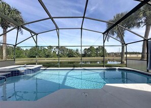 A covered outdoor swimming pool with a view of the surrounding landscape. - Orlando Disney World Be Our Guest Four Bedroom Villa (Kissimmee)
