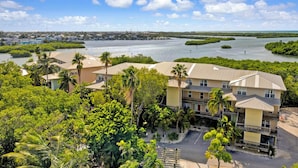 A coastal hotel with multiple buildings, surrounded by lush greenery and mangrove areas. - Barracuda Bay Two Bedroom Condo (Stock Island)