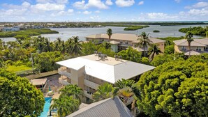 Zona residencial con piscina, varias casas y vista a un cuerpo de agua.