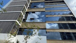 En hög byggnad med många våningar, stora fönster och en modern arkitektonisk design.