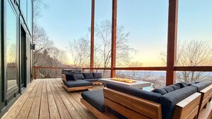 Una terraza de madera con asientos integrados y una chimenea.