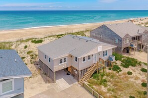 A beachfront property with multiple buildings, including a main house with a deck and a smaller structure. - JL #291 | Kingfisher | Oceanfront | Ocean Views (Kill Devil Hills)