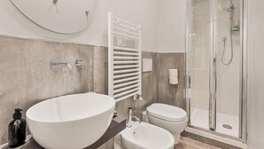 A modern bathroom with a large oval sink, a toilet, and a glass-enclosed shower. - Rooms La Spezia (La Spezia)