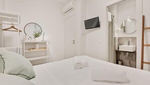 A hotel room with a bed, a TV, a bathroom with a sink, and a mirror. - Rooms La Spezia (La Spezia)
