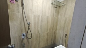 Une salle de bain avec douche, toilettes et lavabo.