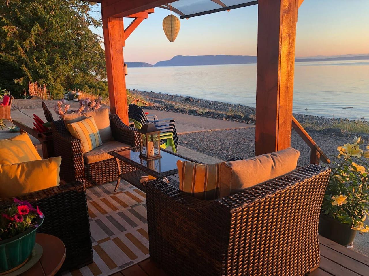 An outdoor seating area with wicker furniture and a view of the water.