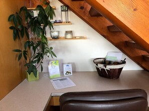 Un escriptori amb una planta, un cistell i alguns documents.