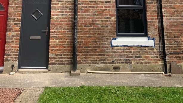 A brick building with a black door, two windows, and a chimney. - Peaceful 1 bedroom house. Dog friendly, centrally located hidden gem. (Morpeth)