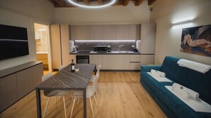 Una cocina moderna con comedor, sofá y un cuadro en la pared.