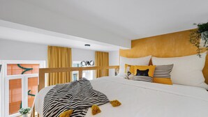 Una camera da letto con un letto, tende, una testiera e una finestra.