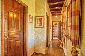 A hallway with wooden doors, a textured wall, and a ceiling with exposed beams. - Astrakeri Gardens Villa (Corfu)