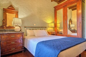 A bedroom with a bed, wooden dresser, and two bedside lamps. - Astrakeri Gardens Villa (Corfu)