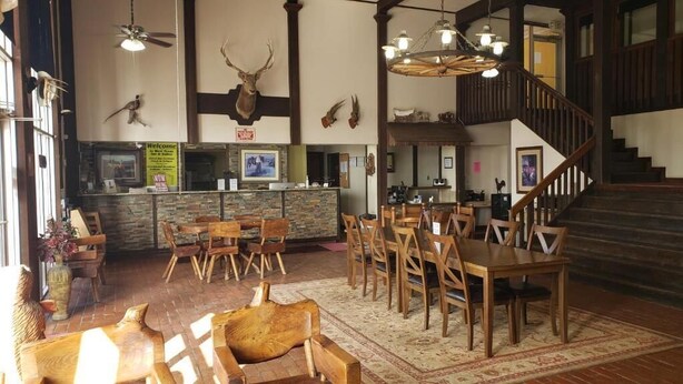Un restaurant avec des meubles en bois, un comptoir en pierre et des bois de cerf accrochés aux murs.