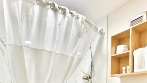 Une salle de bain avec une baignoire, des toilettes et un rideau de douche.