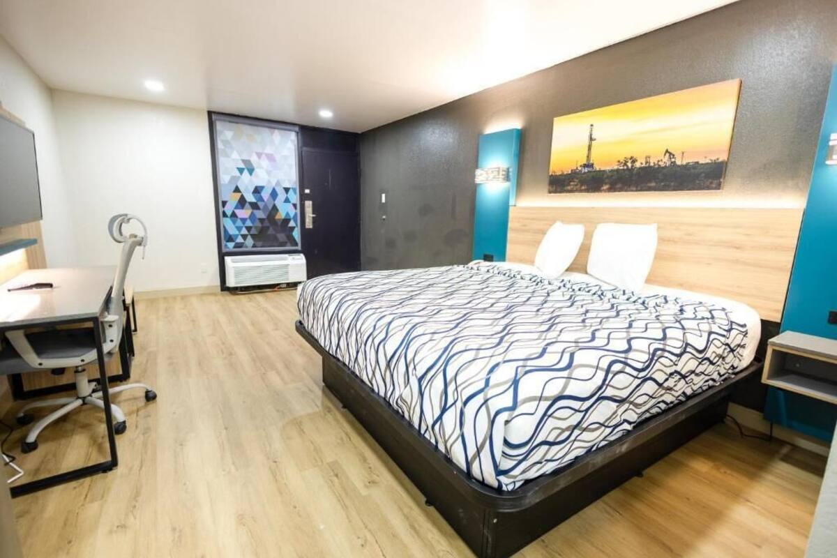 A bedroom with a bed, a desk, and a chair.