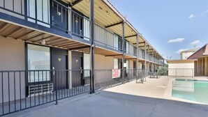 Un hôtel à plusieurs étages doté de balcons, d’un espace piscine et d’un panneau indiquant qu’il est interdit de fumer.