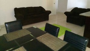 Un salon comprenant un canapé, une table basse et une table à manger avec des chaises.