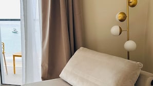 Ein Zimmer mit einer Couch, Meerblick und einer Stehlampe.