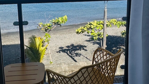 Ein Balkon mit Blick auf das Meer, drei Segelboote und eine Sitzgelegenheit im Freien.