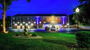 A hotel with a modern brick facade, multiple windows, and a covered parking area. - Best Western Cape Cod Hotel (Hyannis)