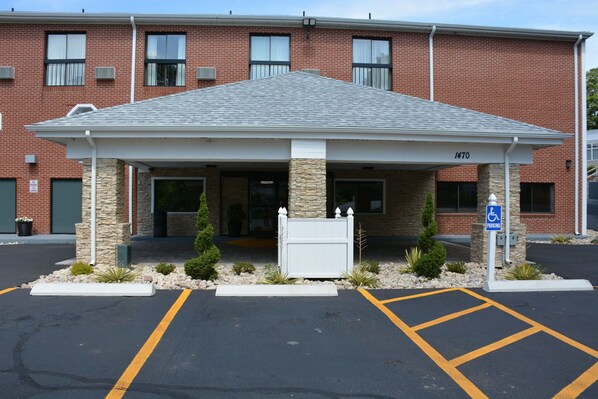 A brick building with a covered entrance, a handicap parking sign, and a building number 1470. - Best Western Cape Cod Hotel (Hyannis)