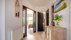 A hallway with a radiator, a wooden cabinet, and a painting on the wall.