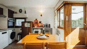 Una cucina compatta con zona pranzo, lavatrice e un'ampia finestra.