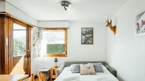 Una camera da letto con un letto, una finestra, una lampada e una decorazione a testa di cervo.