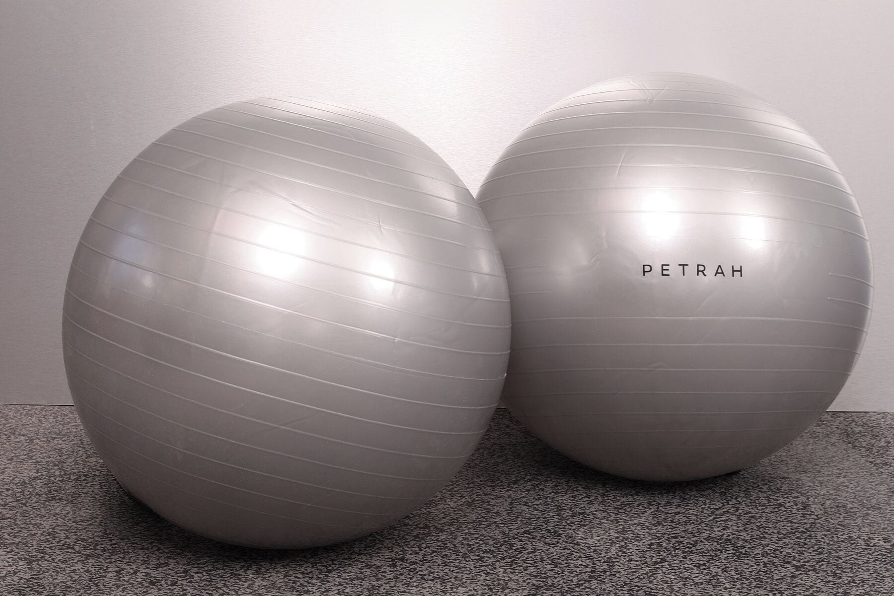 To store, grå træningsbolde med ordet 'PETRAH' på den ene.