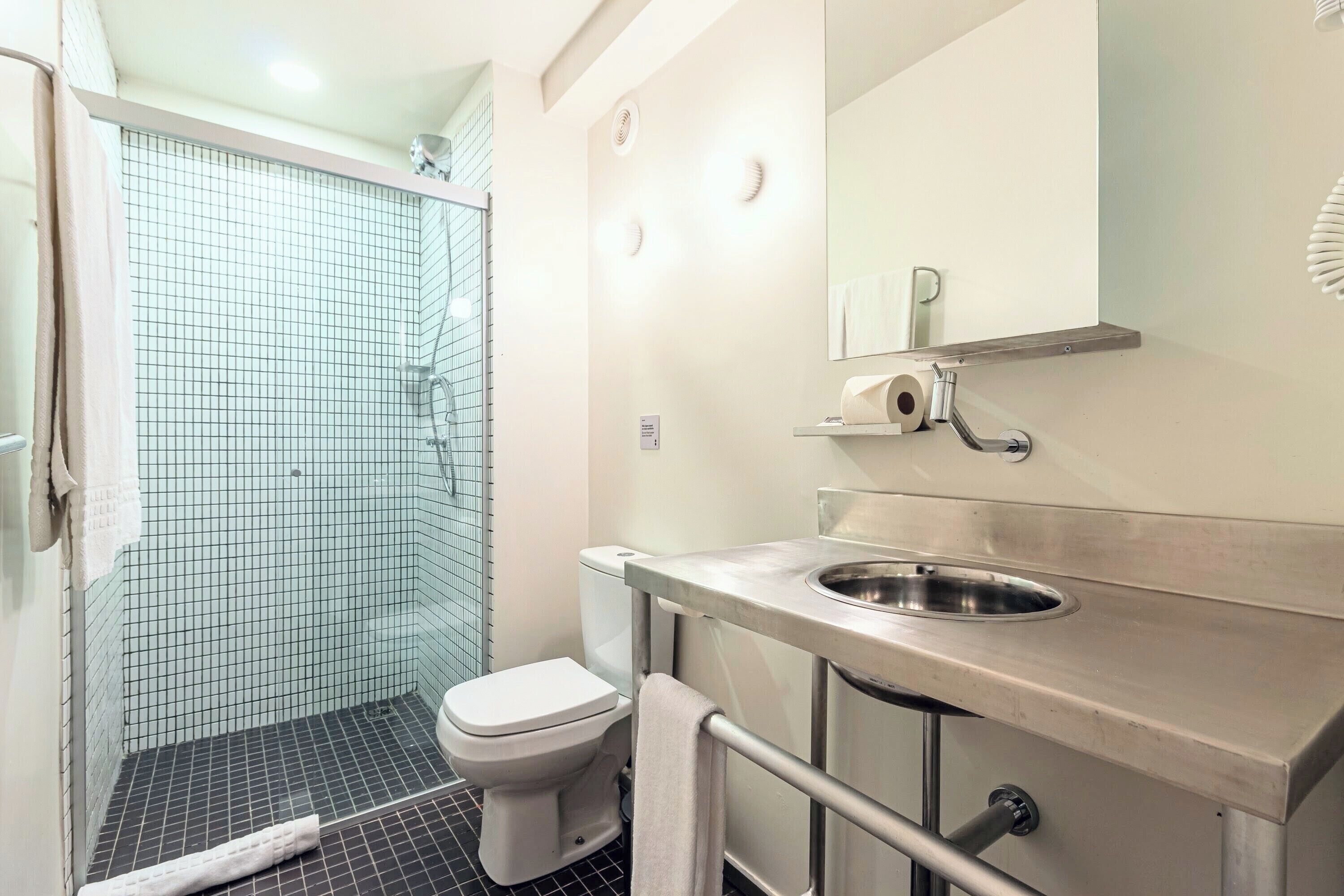 A bathroom with a shower, toilet, and sink.