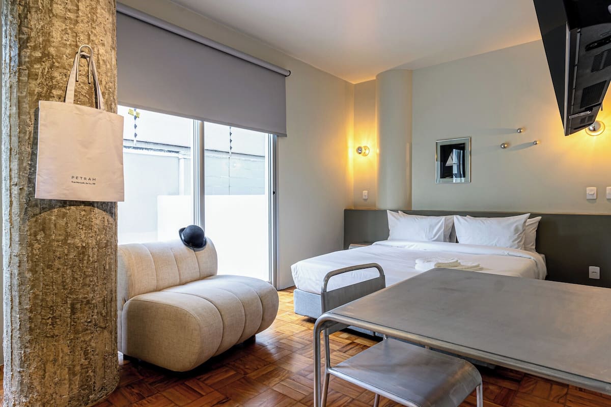 Een hotelkamer met een bank, een bed, een tafel en een televisie.