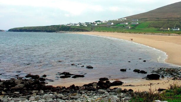 A coastal landscape with a sandy beach, rocky shoreline, and houses on a hillside. - 3 Bed in Achill Island (oc-ii06848) (Doogort)