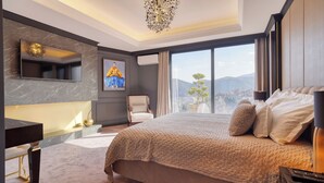 Une chambre d’hôtel moderne dotée d’un grand lit, d’un bureau, d’une chaise, d’une télévision et offrant une vue sur la ville.