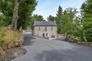 A stone building with a paved driveway and a metal gate. - 2 Bed in Foxford (oc-ii15531) (Callow)