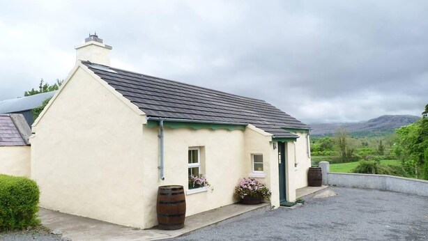 A small, single-story building with a sloped roof, a green door, and windows. - 1 Bed in Ballysadare (oc-ii14644) (Drumiskabole West)
