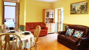 A living room with a dining table, chairs, a sofa, a cabinet, and a painting on the wall. - 1 Bed in Ballysadare (oc-ii14644) (Drumiskabole West)