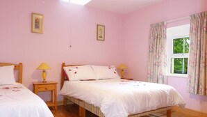 A bedroom with two beds, wooden flooring, a window with curtains, and two bedside lamps. - 1 Bed in Ballysadare (oc-ii14644) (Drumiskabole West)