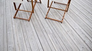 A wooden deck with two chairs.